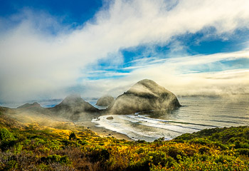 Sisters Rock State Park, Oregon | Driving south from Port Orford in a dense summer sea fog, the late evening breeze magically offered me this glimpse of Sisters Rock. I had to pull over and make photographs until the fog began to settle in again.