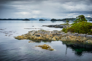 Solo Kayaker, Broughton Archipelago, BC, | Solo Kayaker paddles through the glassy waters of the Broughton Archipelago, BC.