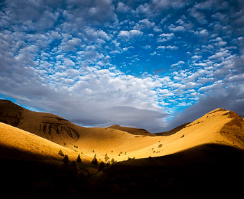 Lower Gorge, John Day River, OR | Setting sun spectacularly illuminates golden hillside and dramatic clouds in the John Day River Canyon.